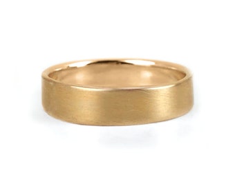 May include: A simple gold wedding band with a brushed finish.
