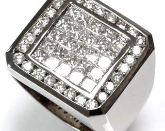 May include: A square-shaped ring with a large, square-cut diamond center stone surrounded by smaller diamonds. The ring is made of white metal and has a polished finish.
