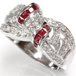 May include: A silver ring with a white and red design. The ring is set with small diamonds and red rubies.