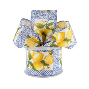 May include: A spool of blue and white patterned ribbon with a lemon print. The ribbon is wrapped around a white spool.