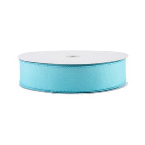 May include: A spool of light blue satin ribbon.