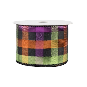 May include: A spool of wired ribbon featuring a metallic plaid pattern in vibrant shades of purple, orange, lime green, and black. The fabric has a shimmering, reflective finish throughout the checkered design, wound around a white cardboard core.