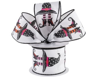 Puede incluir: Cinta blanca con estampado de sombrero de bruja y piernas negras y rosas. La cinta está en un carrete y tiene un borde negro.