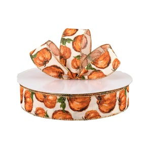 May include: A decorative ribbon spool featuring a repeating pattern of orange pumpkins on a cream background. The ribbon is accented with gold trim and is ideal for fall-themed crafts and decorations.