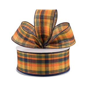 May include: A roll of orange, yellow, green, and blue plaid ribbon with a navy blue edge. The ribbon is tied into a bow on top of the roll.