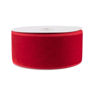 May include: A spool of red velvet ribbon. The ribbon is wound around a white cardboard spool.