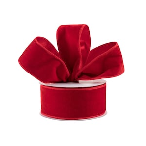May include: A spool of red velvet ribbon with a bow tied on top. The ribbon is 2.5 inches wide.