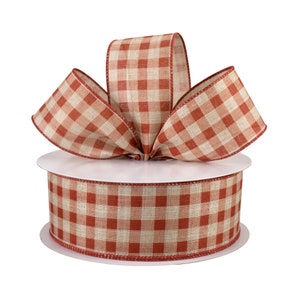May include: A spool of red and natural burlap gingham ribbon. The ribbon is tied into a bow on the spool.