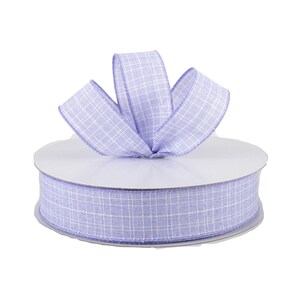 May include: A roll of lavender checkered ribbon with white lines. The ribbon is wrapped around a white cardboard spool.