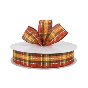 May include: A spool of plaid ribbon with a bow tied on top. The ribbon is red, orange, yellow, green, and white.