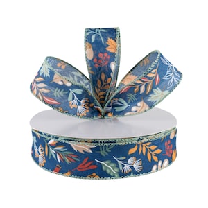 May include: A decorative ribbon with a fall-themed pattern. The ribbon features a dark blue background with colorful leaves, acorns, and berries in shades of orange, green, and white. The edges are trimmed with a light green border. The ribbon is on a white spool.