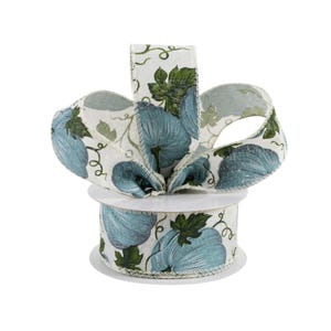 May include: A roll of white fabric ribbon with a blue and green pumpkin print. The ribbon is 2.5 inches wide and has a wired edge.