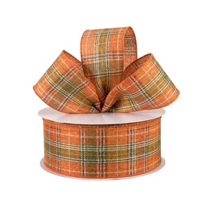 May include: A spool of orange and green plaid ribbon with a bow tied on top. The ribbon is made of a woven fabric with a rustic look.