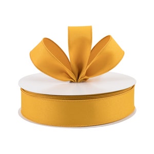 May include: A spool of yellow satin ribbon with a bow tied on top. The ribbon is 2.5 inches wide.