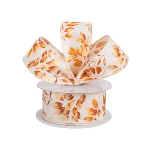 May include: A decorative ribbon featuring a cream-colored background with a repeating pattern of autumn leaves in shades of orange and brown. The ribbon is formed into a bow, and is on a spool.