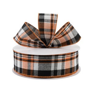 May include: A spool of orange, black, and white plaid ribbon. The ribbon is tied into a bow on top of the spool.