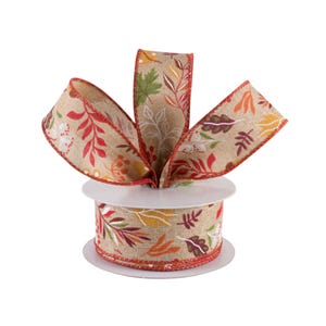 May include: A roll of brown burlap ribbon with a red, orange, yellow, and green leaf print. The ribbon is tied in a bow and is on a white spool.
