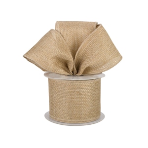 May include: A spool of tan, woven fabric ribbon with a textured, burlap-like appearance. The ribbon is wrapped around a white plastic core, with a portion of the ribbon folded at the top to display its width and consistent, neutral-toned weave.