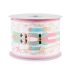 May include: A roll of pink and white ribbon with a repeating pattern of a nutcracker in blue, green, and gold. The nutcracker is holding a candy cane.