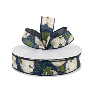 May include: A spool of navy blue ribbon with a white pumpkin and green leaf pattern.