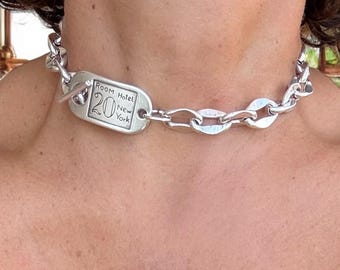 Halsband i kraftigt silverkedjeformat med skulpterat knäppe. Handgjort i försilvrat stål. Industrismycken