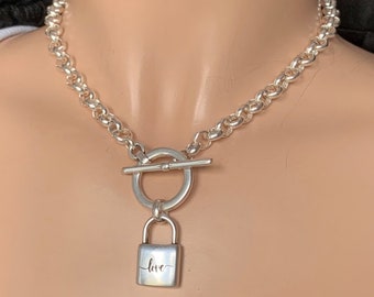 May include: Silver chain necklace with a toggle clasp and a padlock pendant that says "love" on it.
