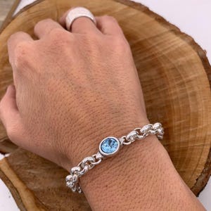 Bracciale a catena spessa in argento con elemento centrale in cristallo Swarovski, gioiello audace e personalizzato.