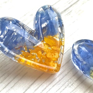 Heart brooch made of epoxy resin with yellow-blue petals.