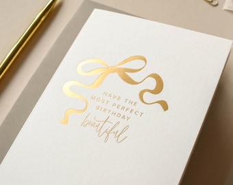 Belle carte d'anniversaire avec un noeud pour elle en feuille d'or ou en feuille d'or rose