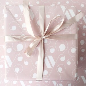 May include: A pink gift box with a white swirl pattern and a satin ribbon tied in a bow.