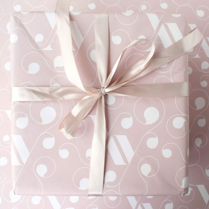 May include: A pink gift box with a white swirl pattern and a satin ribbon tied in a bow.