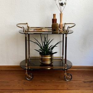 Jaren 60 gouden barwagen van messing met twee lagen donker getint glas.