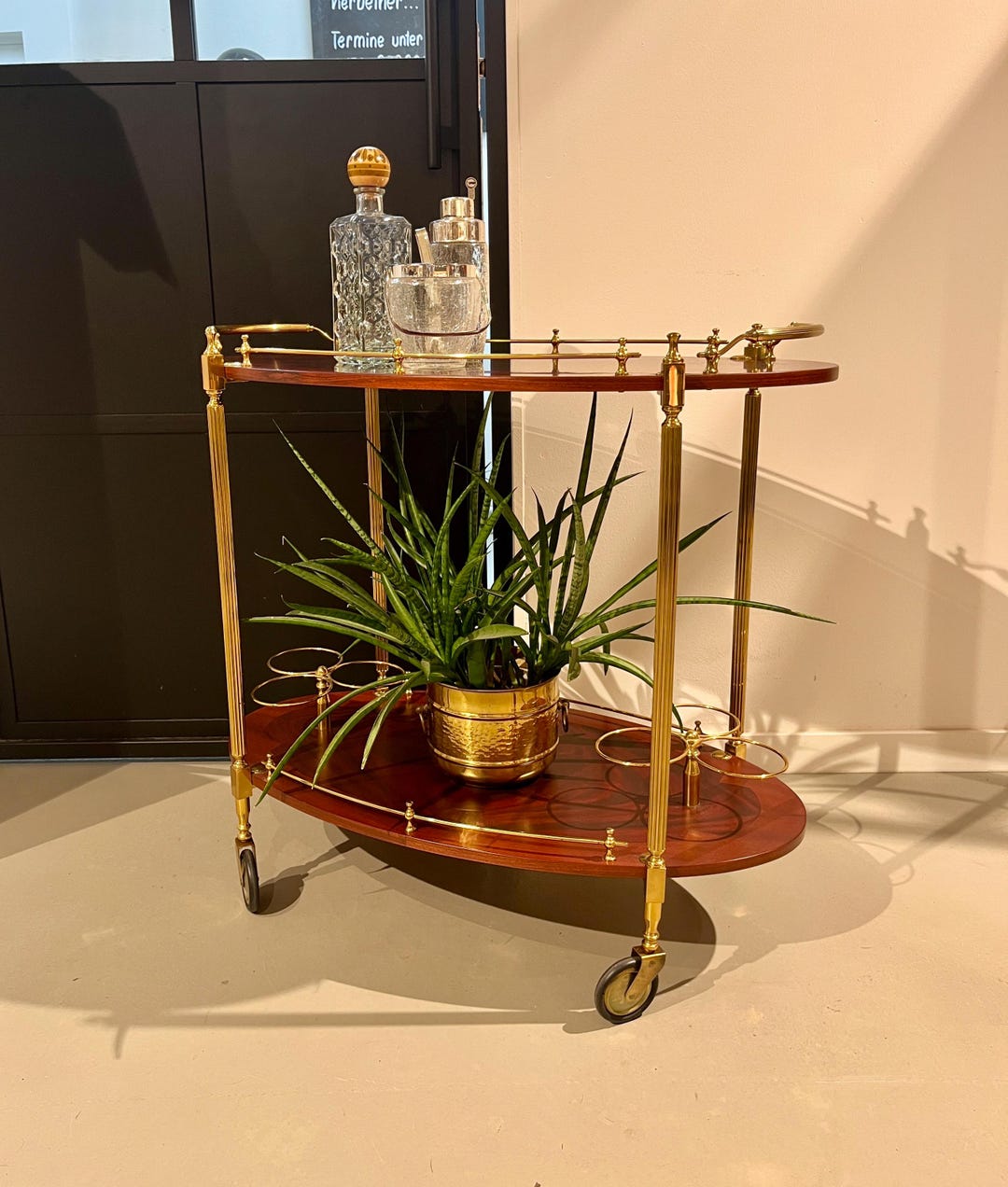 金色の真鍮フレームに車輪がついたイタリア製のバーカートです