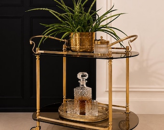 1960s gold brass bar trolley with two tiers of dark tinted glass.