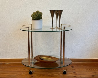 1970's golden brass bar trolley with two tinted glass tops on wheels.