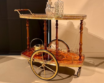Neoclassical bar cart with an inlaid pattern on wheels.