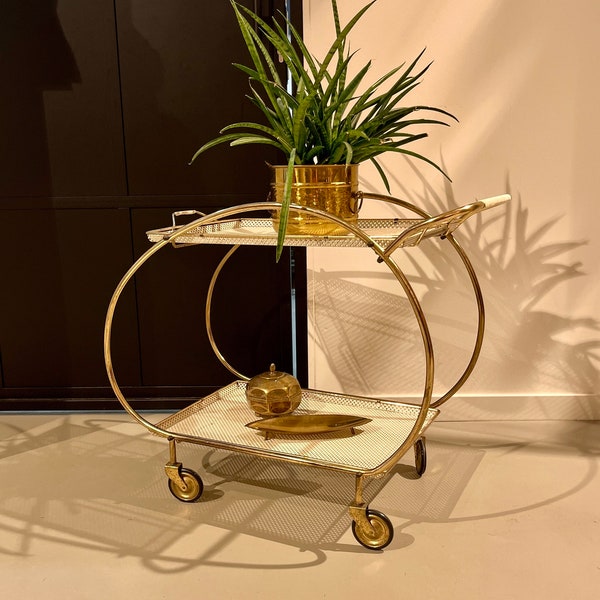 Art Deco 1930s golden bar cart made of brass on rubber-tired wheels.