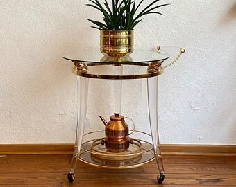 Italian bar cart with a gold brass and plexiglass frame on wheels.