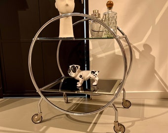 Art Deco bar cart with a silver frame on wheels.