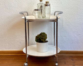 Chariot de service chromé des années 1970 avec plateaux blancs.