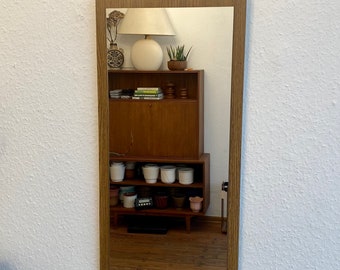 Mid Century 60s wall mirror with a wooden frame.