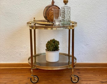 Neoclassical brass bar trolley on casters.