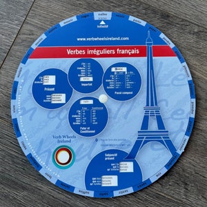 Può includere: Uno strumento di apprendimento circolare blu e bianco con un'immagine della Torre Eiffel. Lo strumento è una ruota di verbi francese con il titolo "Verbes irréguliers français" e il sito web "www.verbwheelsireland.com".
