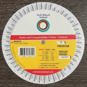 Peut inclure: Une roue circulaire jaune et rouge avec un centre blanc. La roue est divisée en sections avec des mots allemands pour les verbes. La roue est intitulée "Verb Wheels Ireland" et "Starke und Unregelmäßige Verben - Deutsch".
