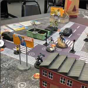 36インチ x 36インチの第3版マーベルクライシスプロトコルグリップマット（ステッチエッジ付き）には「A」目標が含まれています