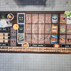 May include: A board game with a wooden design, featuring various cards, labels, and illustrations. The game board includes sections labeled "Spirit Awards," "Spirit Labels," "Premium Market," and "Basic Market." The game's theme appears to be related to spirits and flavours.
