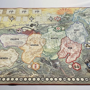 May include: A detailed game board depicting a map of Japan with various regions labeled in Japanese. The board is made of thick cardboard and features a colorful, illustrated design. The board is surrounded by a red border and a series of numbered circles.