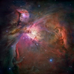 May include: A vibrant nebula with swirling clouds of pink, red, and blue gas. The nebula is filled with stars, some of which are bright and white, while others are faint and distant.