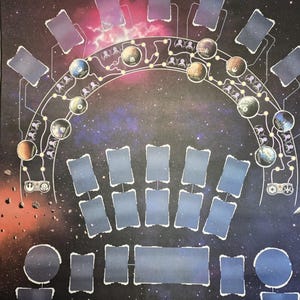 Op de afbeelding: Een spelmat met een ruimtethema. De mat heeft een donkere achtergrond met planeten, sterren en een netwerk van onderling verbonden lijnen. Rechthoekige en cirkelvormige ruimtes zijn over de mat gerangschikt, waarschijnlijk voor spelonderdelen.