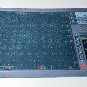 Könnte beinhalten: Eine rechteckige, blau-graue Matte mit detailliertem Rastermuster und integriertem Bedienfeld. Die Matte weist eine Reihe von Quadraten, rote Akzente und den Text "Wellipod" auf. Das Bedienfeld enthält einen Schieberegler und verschiedene Tasten.